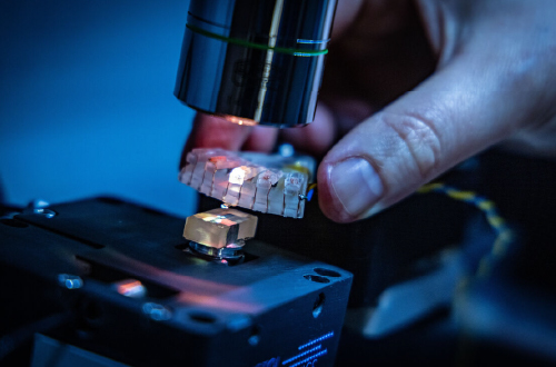 A microscope shining a light on a cable and composite material.